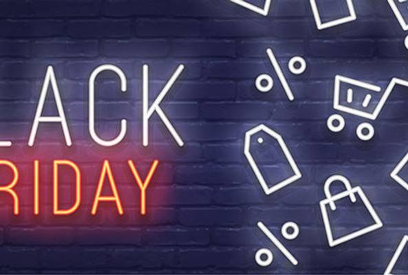 Black Friday neon sign on brick wall with shopping icons and sale symbols background.
