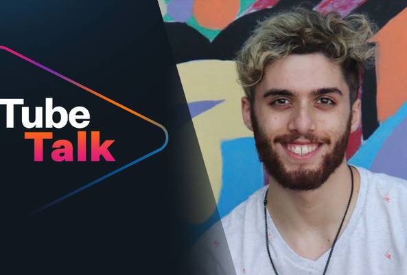 Smiling young man with colorful background next to Tube Talk logo for video content.