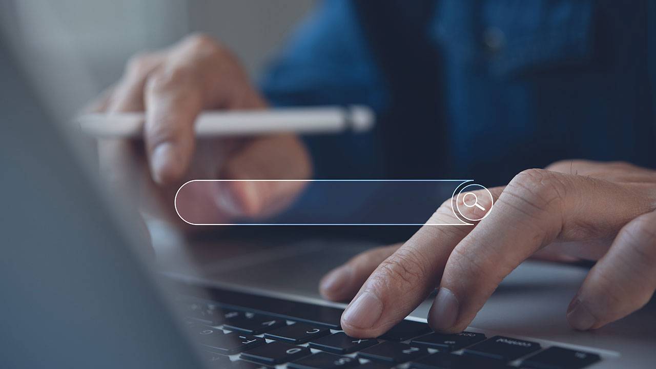 A search bar overlayed on top of the image of man typing