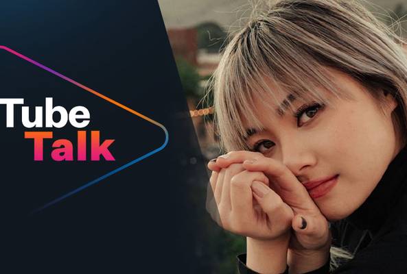 Woman with blonde hair in black sweater beside Tube Talk logo on dark background
