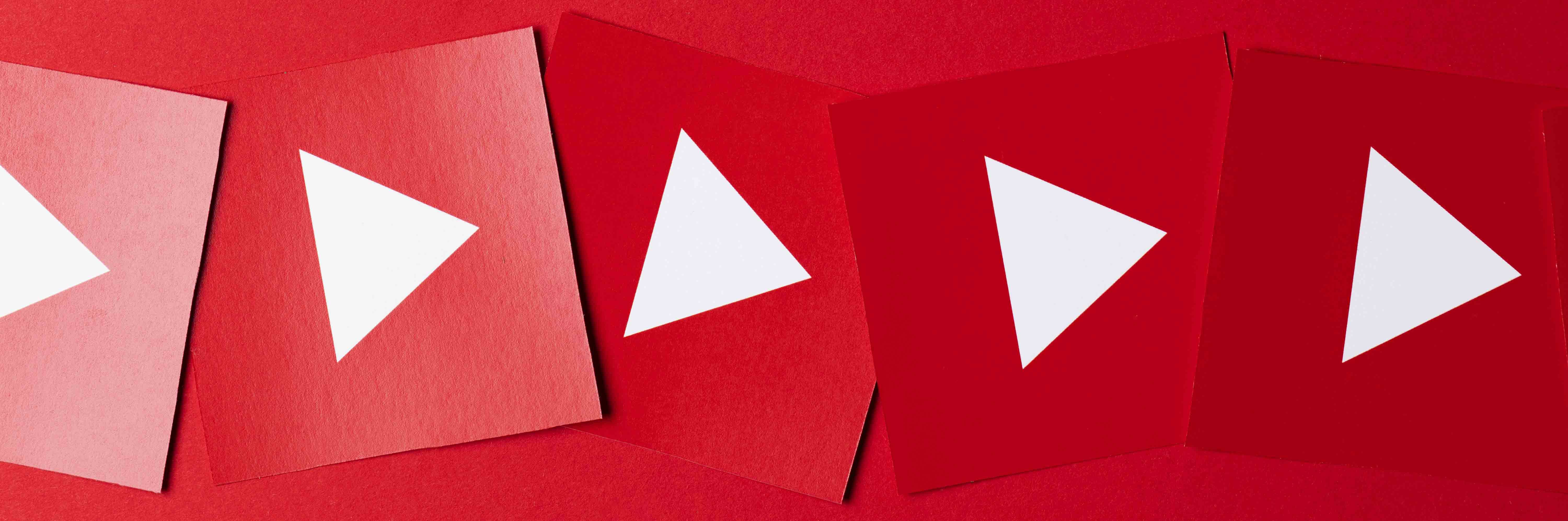 Multiple red cards with white play buttons symbolizing video streaming or YouTube icons.