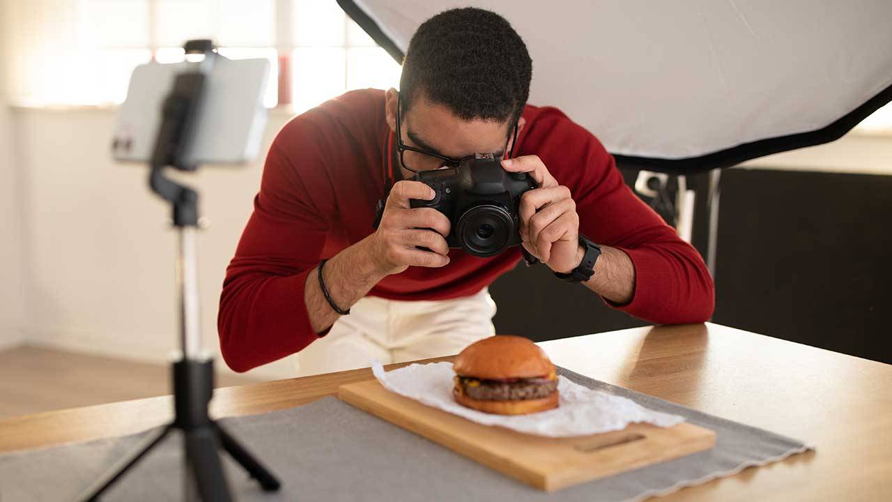 Man filming a burger up close