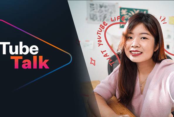 Young woman recording vlog for Tube Talk podcast with logo and creative background text.