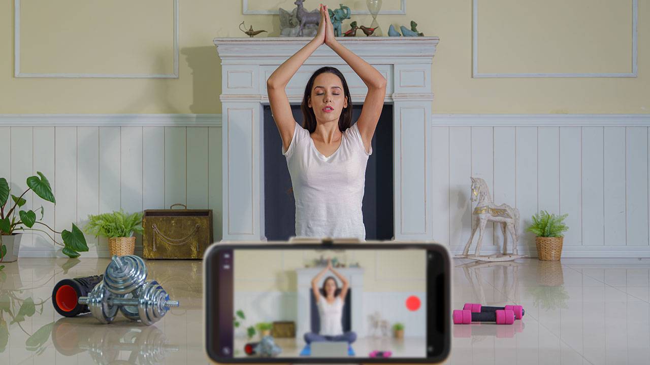 Female fitness youtuber filming yoga workout