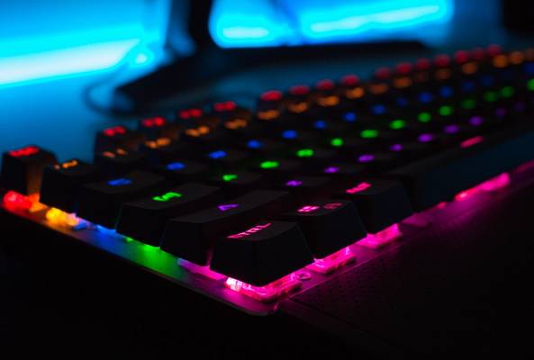 RGB mechanical gaming keyboard close-up with colorful backlit keys in dark setup