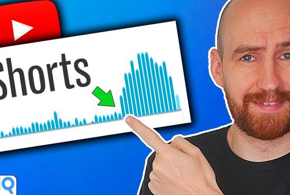 Man pointing at a YouTube Shorts graph showing growth in video views and engagement.