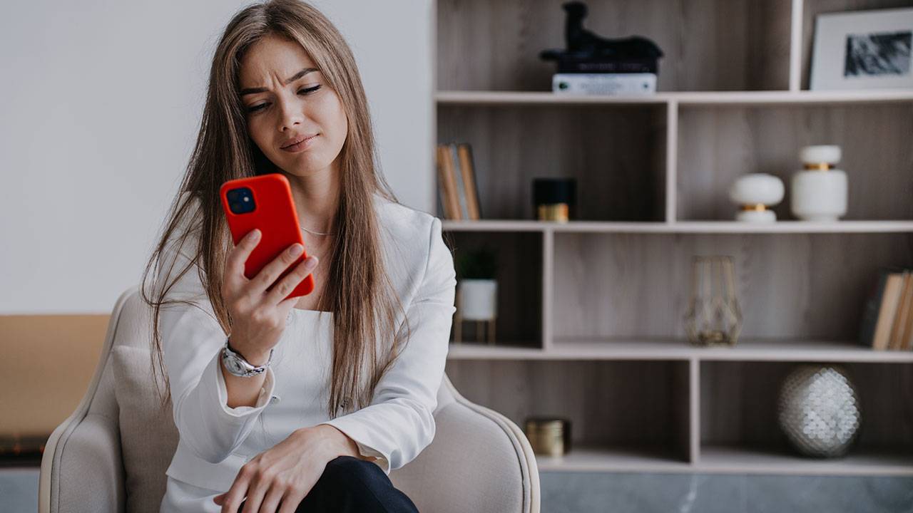 woman starring at phone in confusion