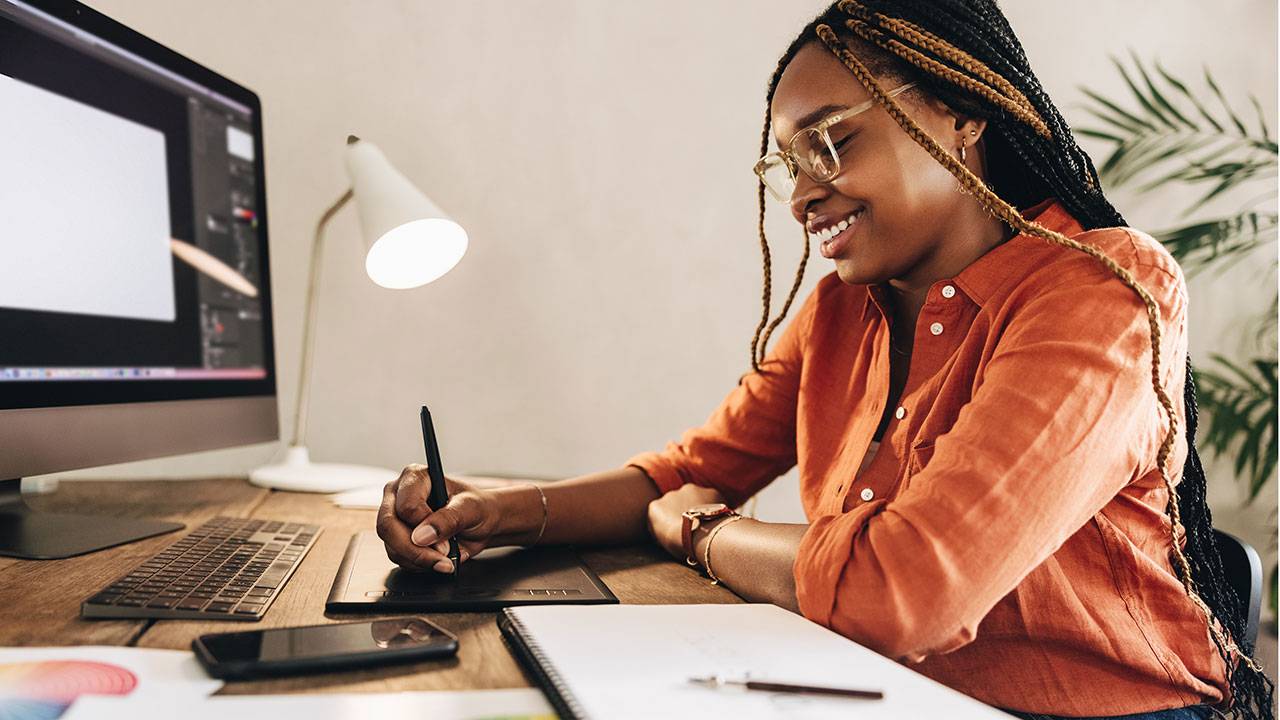 Woman designing YouTube thumbnail with drawing pad on computer