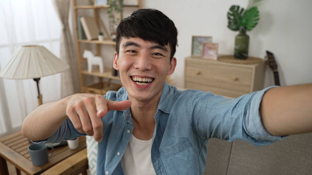 A man pointing at the camera and smiling