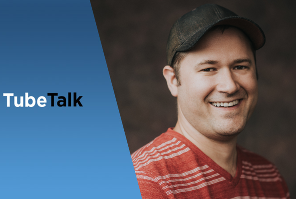 Smiling man in red striped shirt and cap with TubeTalk logo on blue background