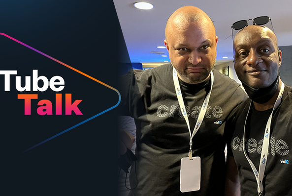 Two men wearing vidIQ shirts at TubeTalk event with logo on dark background